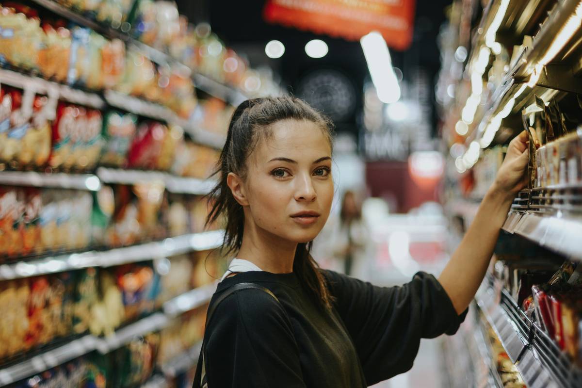 Woman comparing prices during Supermarket Deals at Kings Supermarkets